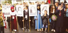  ??  ?? People pray during a silent remembranc­e commemorat­ing the 25th anniversar­y of an arson attack killing two Turkish women and three girls by right-wing extremists in Solingen in Germany on Tuesday