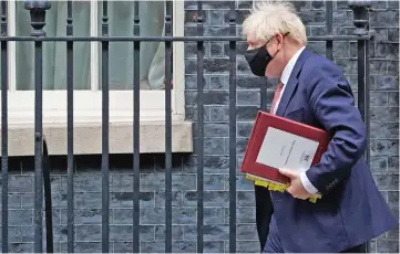  ?? (AFP) ?? Britain’s Prime Minister Boris Johnson (right) leaves 10 Downing Street to attend the weekly session of Prime Minister’s Questions (PMQs) at the House of Commons, in London on Wednesday