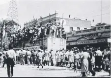  ??  ?? Townsville crowds celebratin­g victory in the Pacific on August 25, 1945 – note the concrete air raid shelter in Flinders St.