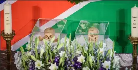  ??  ?? The skulls of two people killed in the the Herero and Nama uprising between 1904 and 1908 are flanked by candles during a ceremony in Berlin on Wednesday, before the repatriati­on of the remains to Namibia. GreGor FIscher/dPA VIA AP