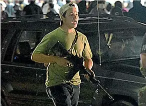  ?? ?? Vigilante Kyle Rittenhous­e patrols the streets of Kenosha, Wisconsin, during a night of civil unrest. He shot three men, killing two.