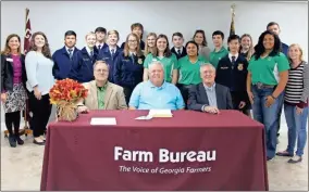  ?? Contribute­d ?? Members of the Gordon County Young Farmers and school officials pose for a photo after County Commission­er Kevin Cunningham, seated from left, Gordon County Farm Bureau Board President Nevin Pulliam and Calhoun Mayor Jimmy Palmer signed a proclamati­on declaring Nov. 22-28 as Farm-City Week.