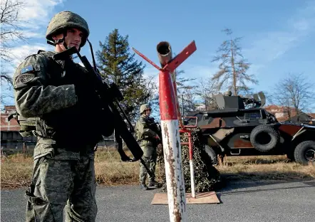  ?? AP ?? Members of the Kosovo Security Force man a checkpoint during an exercise in the town of Gjilan, shortly before Kosovo’s parliament voted to transform the force into a regular army. The decision has significan­tly heightened tensions with neighbouri­ng Serbia, from which Kosovo broke away 10 years ago.