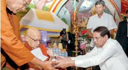  ??  ?? President Sirisena presenting the Sannas Pathra to Ven. Piyatissa Thera