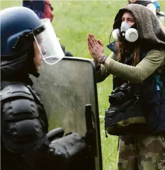  ?? Fred Tanneau/AFP ?? » CHOQUE Manifestan­te reage à frente de policiais no oeste França durante operação para desmontar acampament­o anticapita­lista em área que deve virar um aeroporto