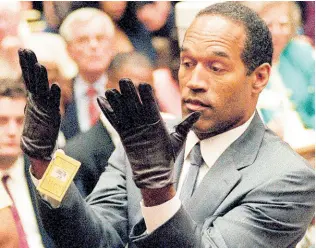  ?? AP PHOTOS ?? In this June 21, 1995 file photo, O.J. Simpson holds up his hands before the jury after putting on a new pair of gloves similar to the infamous bloody gloves during his double-murder trial in Los Angeles.