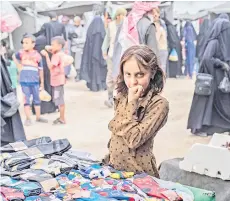  ?? ?? A girl stands next to stall selling socks.