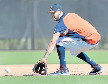  ??  ?? Houston Astros infielder Carlos Correa handles a grounder during spring training practice in West Palm Beach, Florida.