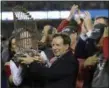  ?? DAVID J. PHILLIP - THE ASSOCIATED PRESS ?? File- This Oct. 28, 2018, shows Boston Red Sox owner John Henry, partially hidden at left, and chairman Tom Werner holding the championsh­ip trophy beside manager Alex Cora, right, after Game 5of baseball’s World Series against the Los Angeles Dodgers in Los Angeles.