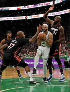  ?? STUART CAHILL / HERALD STAFF ?? NEW DAD: Derrick White pulls in a rebound between Miami’s P.J. Tucker (17) and Dewayne Dedmon last night.