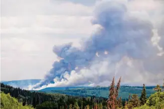  ?? Noah Berger/Associated Press ?? Smoke billows last Sunday from the Donnie Creek wildfire burning north of Fort St. John, British Columbia. The fumes from such fires have polluted the atmosphere.