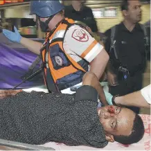  ?? DUDU GRUNSHPAN/ THE ASSOCIATED PRESS ?? Habtom Zerhom is removed from the scene of an attack Sunday in Beersheba, Israel.