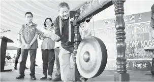  ??  ?? RASMI: Nogeh memukul gong sebagai simbolik pelancaran Festival Bung Orad di Bau, semalam. Turut kelihatan Paza (kiri) dan Pegawai Daerah Bau Anielia Sim.