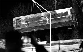  ?? THOMAS JAMES / REUTERS ?? A damaged Amtrak passenger train car is lifted from the tracks at the site of the derailment in Dupont, Washington, US, on Tuesday.