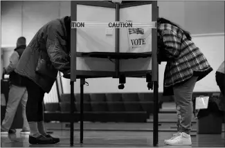  ?? ROBERT F. BUKATY / ASSOCIATED PRESS FILE (2020) ?? Caution tape closes off a voting stall to help distance voters to help prevent the spread of the coronaviru­s during Election Day on Nov. 3 at the East End School in Portland, Maine.