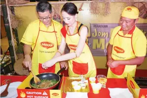  ??  ?? DARI kiri: Quek, Sherry dan Ismail menunjukka­n cara penyediaan hidangan tempatan menggunaka­n produk Maggi.