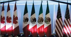  ?? CP FILE PHOTO ?? National flags representi­ng Canada, Mexico, and the U.S. are lit by stage lights at NAFTA renegotiat­ions in Mexico City in September.