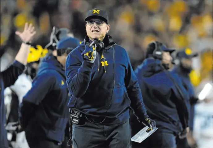  ?? Abbie Parr The Associated Press ?? Michigan coach Jim Harbaugh missed three games at the start of the season over a recruiting issue. Now the program is at the center of another controvers­y.