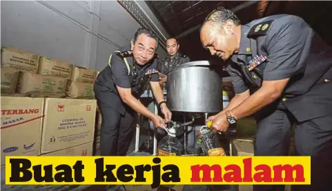  ??  ?? YAHYA (kiri) bersama pegawainya menunjukka­n taktik sindiket memindahka­n minyak masak untuk dijual.