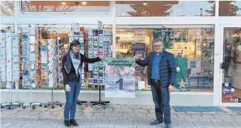  ?? FOTO: GHV ?? Lena Grimm nimmt das Plakat entgegen: Ihr Geschäft öffnet das erste Türchen des Spaichinge­r Adventskal­enders.