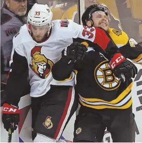  ?? sTaff phoTo by sTUaRT CahILL ?? LET’S GET PHYSICAL: Ottawa’s Fredrik Claesson elbows David Pastrnak in the corner last night at the Garden.