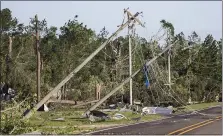  ?? BRETT COOMER - THE ASSOCIATED PRESS FILE PHOTO ?? In this April 23, 2020file photo, utility poles are knocked off their foundation, dropping power lines, after a tornado ripped a swath of destructio­n through the area in Onalaska, Texas.