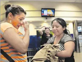  ?? Bob Owen
San Antonio Express-News ?? A WOMAN wipes away tears after running into a friend from a Texas immigrant family detention center at a Greyhound bus station in San Antonio.