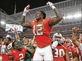  ?? AL DIAZ / ADIAZ@MIAMIHERAL­D.COM ?? UM’s Malek Young wears the turnover chain after intercepti­ng a pass in the second quarter against Notre Dame at Hard Rock Stadium on Nov. 11.