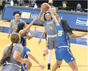  ?? KARL MERTON FERRON/THE BALTIMORE SUN ?? Towson Tigers guard Aleah Nelson (4), a McDonogh grad, passes between Hofstra guard JaKayla Brown (St. Mary’s Ryken, LaPlata) and center Zyheima Swint (13) on Saturday. The Tigers held on to tame the Pride 65-60 at Towson.