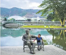  ?? AP ?? A child sits next to a monument of late President Hugo Chavez at Hugo Chavez Park in Caracas, Venezuela, on May 14. The United States government is considerin­g lifting some economic sanctions on Venezuela.
