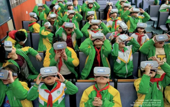  ??  ?? Pupils use VR devices to learn about science and technology in Hunan Province