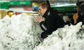  ??  ?? Neil Lennon sits in the snow-covered dugout contemplat­ing Celtic’s 2-2 draw at Livingston. Photograph: Stuart Wallace/BPI/Shuttersto­ck