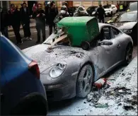  ?? AP/KAMIL ZIHNIOGLU ?? A Porsche parked on a street in Paris was vandalized by yellowvest protesters during clashes with police Saturday.