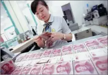  ?? XIE ZHENGYI / FOR CHINA DAILY ?? An employee counts money at a bank in Huaibei, Anhui province.