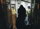  ?? THE ASSOCIATED PRESS ?? On Jan. 22, 2020, Health Officials in hazmat suits wait at the gate to check body temperatur­es of passengers arriving from the city of Wuhan at the airport in Beijing, China.