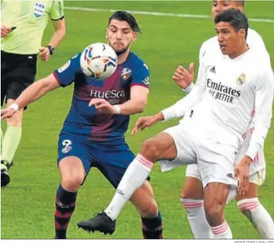  ?? JAVIER CEBOLLADA / EFE ?? El local Rafa Mir disputa el balón con el madridista Varane.