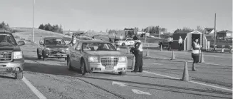  ?? DARRELL COLE/SALTWIRE NETWORK ?? Provincial officials question motorists as they enter Nova Scotia at the inbound weigh scale in Fort Lawrence last week. RCMP assisted provincial officials as they tighten the border as a result of the province’s state of emergency declaratio­n.