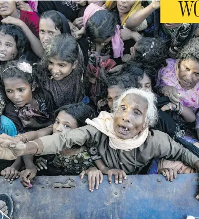  ?? ALLISON JOYCE / GETTY IMAGES ?? Recently arrived Rohingya refugees wait to receive aid on Wednesday in Cox’s Bazar, Bangladesh. An estimated 370,000 Rohingyas have fled to Bangladesh from Myanmar since late August.