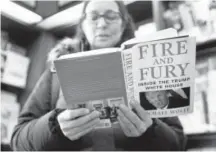  ?? Charles Rex Arbogast, The Associated Press ?? Kathy Mallin looks over a copy of “Fire and Fury” at Barbara’s Bookstore in Chicago.