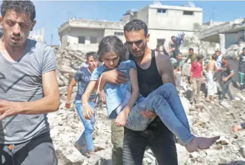  ?? — AFP ?? A man carries a child rescued from rubble after air strikes in the rebel-held town of Nawa, about 30 km north of Daraa in southern Syria, on Wednesday.