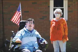  ?? Cloe Poisson / CTMirror.org ?? Penny Barsch, of Meriden, stands six feet away from her son, Shane Sessa, in the back yard of the group home where he lives in Portland. When Sessa, who has cerebral palsy, was hospitaliz­ed recently for surgery, Barsch was prohibited from accompanyi­ng him due to hospital restrictio­ns in place since the onset of the COVID-19 pandemic.