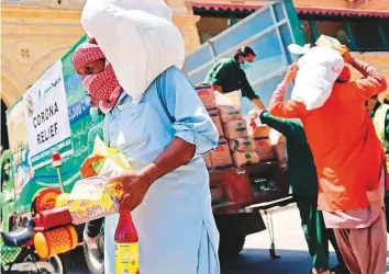  ?? AFP ?? Porters get free essential food items at the Karachi Cantonment railway station. The Supreme
■ Court, while issuing the order, said if coronaviru­s did not kill the people, hunger would.