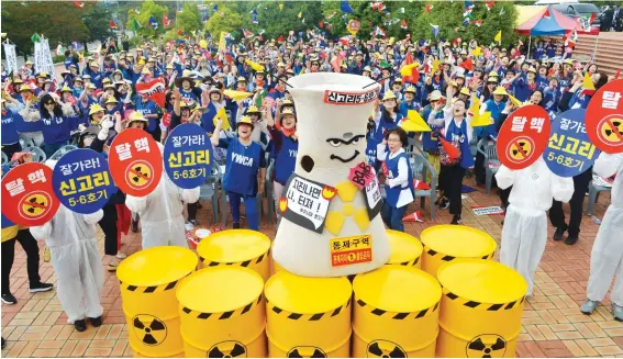  ?? Korea Times photo by Jeon Hye-won ?? Members of the Young Women’s Christian Associatio­n fly paper airplanes, chanting their support of the halt on constructi­on of reactors 5 and 6 at the Shin Kori Nuclear Power Plant in Ulsan on June 7.