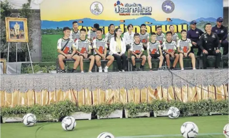  ??  ?? ► Los 12 niños del equipo de fútbol y su entrenador durante la conferenci­a de prensa, ayer en Chiang Rai.