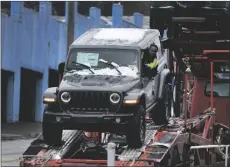  ?? AP PHOTO/GENE J. PUSKAR ?? A new Jeep is delivered to a dealership in Pittsburgh on Monday.