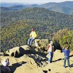  ?? BY JOHN MCCASLIN ?? Two elderly couples celebrate reaching the summit of Mary's Rock in Shenandoah National Park last weekend, capturing the moment on camera.