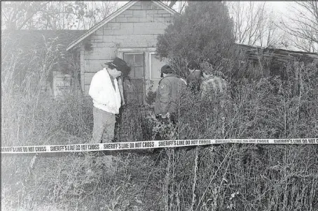  ?? Courtesy photo ?? Local officials investigat­e the skeletal remains of a young female, found by hikers along a remote country road, three miles north of Pineville, according to reports in the Dec. 5, 1990, McDonald County News Gazette. McDonald County Sheriff Lou Keeling, in the white jacket, oversaw the investigat­ion of the unidentifi­ed woman and her unknown killer. The 30-year-old cold case is now getting a renewed review, as a Texas-based firm hopes extensive DNA testing could crack the case.