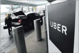  ?? Seth Wenig ?? The Associated Press file A sign marks a pickup point for Uber at Laguardia Airport in New York. New York City is imposing a one-year moratorium on new ride-hailing licenses.