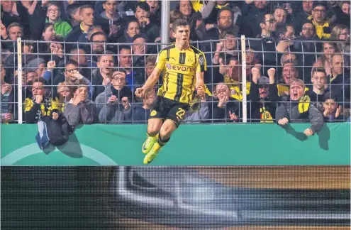  ?? FOTO: DPA ?? Christian Pulisic geht nach seinem Führungstr­effer gegen Lotte vor lauter Jubel in die Luft. Den mitgereist­en Dortmunder Fans gefällt das.