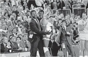  ?? [AP PHOTO/FILE] ?? Georgetown coach John Thompson, left, hugs Patrick Ewing after Georgetown defeated Houston 84-75 for the NCAA title in Seattle on April 2, 1984.